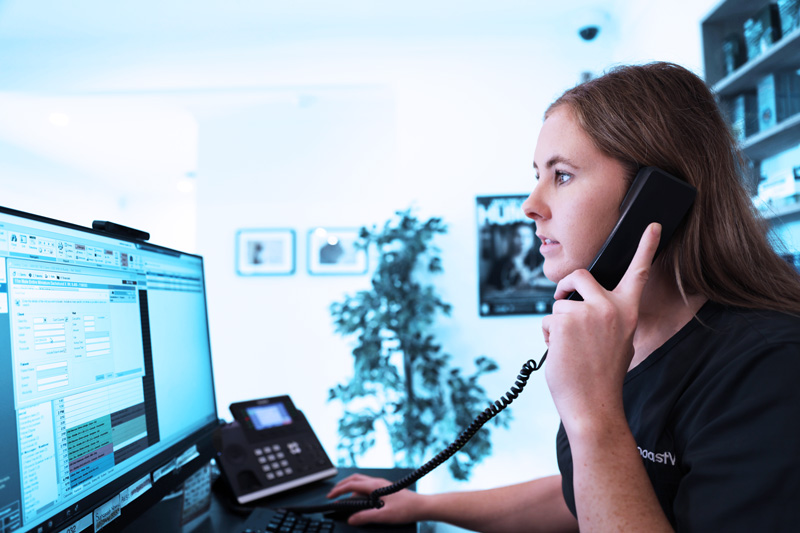 SuncoastVet receptionist answering phone call at clinic desk