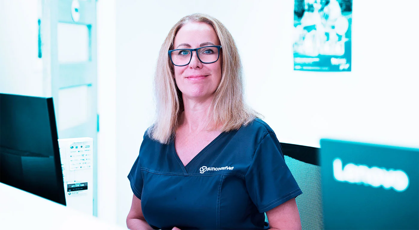 Female SuncoastVet staff member with blonde hair and glasses at clinic reception